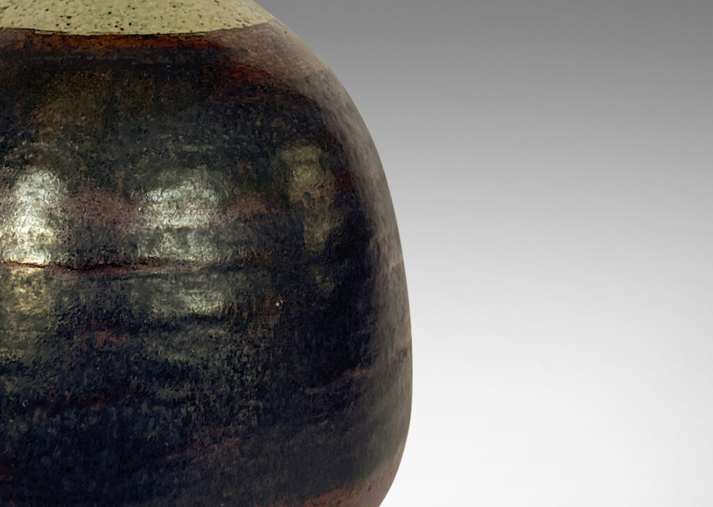 Gallery BAC bulbous form with tall, conical neck, glazed in a black and burgundy luster and speckled gray