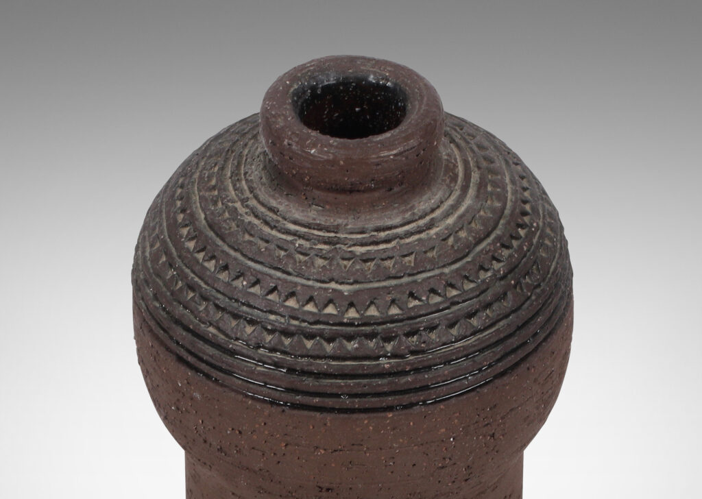 Gallery BAC globe form on a cylinder in matte brown, with rows of carved stripes and impressed triangles