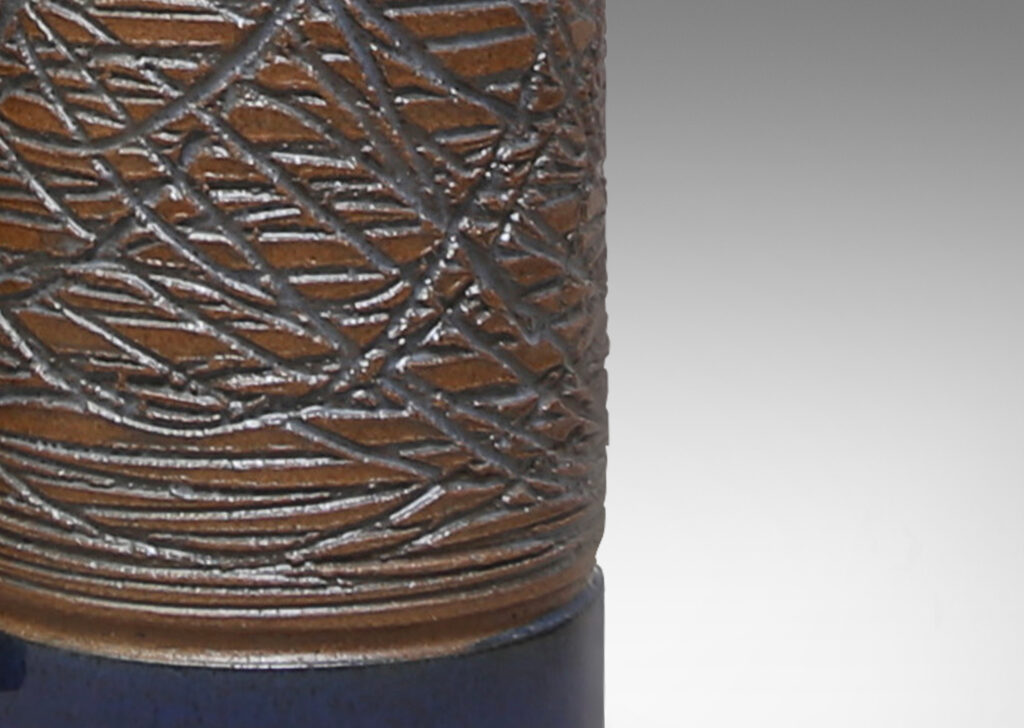 Gallery BAC cylindrical forms carved in a looping grid design and glazed a clear blue-tinted glaze