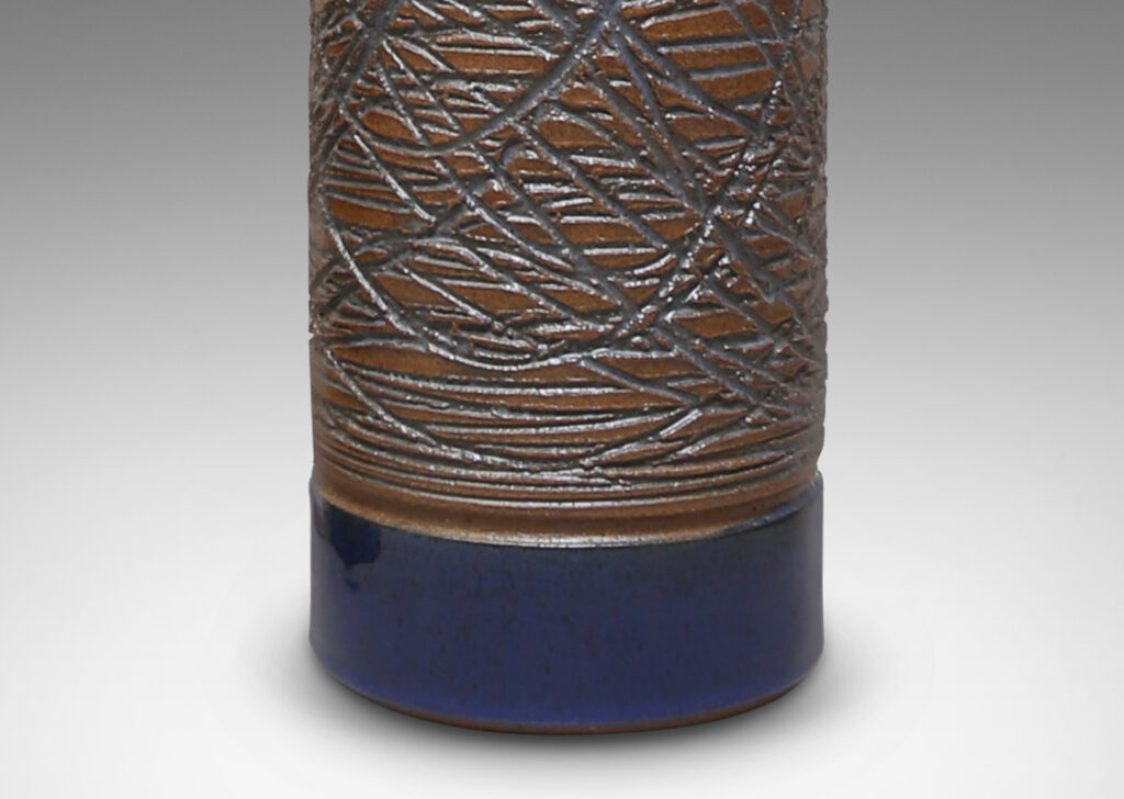 Gallery BAC cylindrical forms carved in a looping grid design and glazed a clear blue-tinted glaze