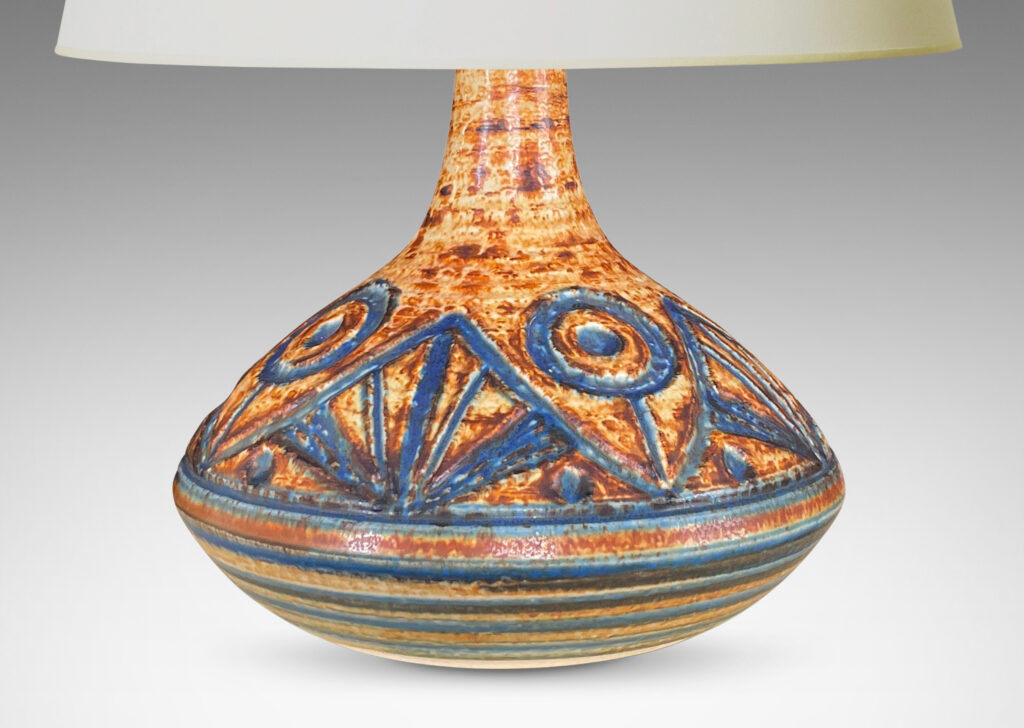 Gallery BAC angled decanter form with carved abstract floral design and stripes in mottled caramel brown with blue-gray glazing