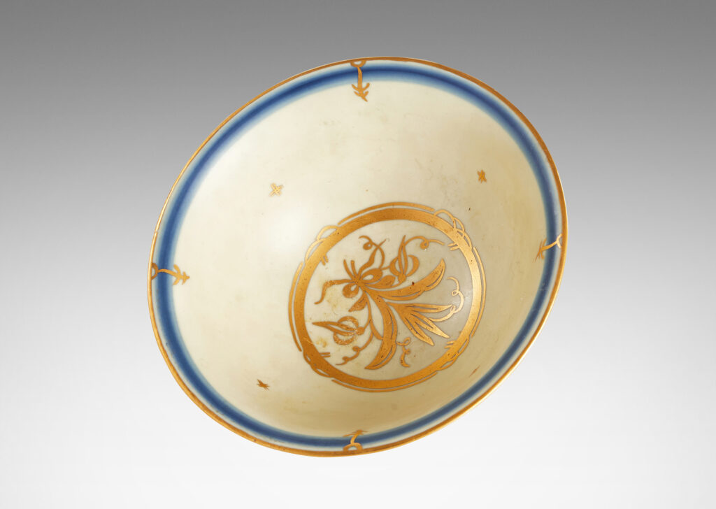 Gallery BAC classic form with flared lip in ivory glaze with soft blue lines around rim and base and gilded floral design inside and edge detail