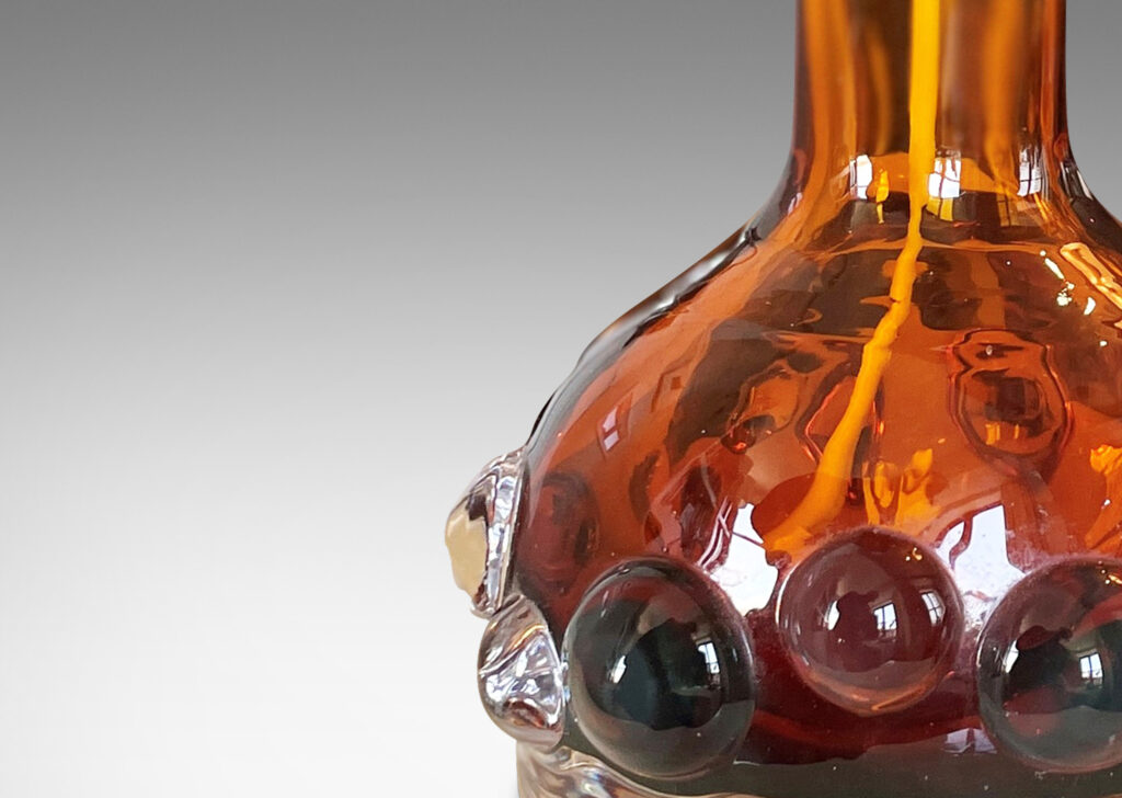 Gallery BAC decanter forms with attenuated necks and applied relief of demi-spheres in amber within clear glass