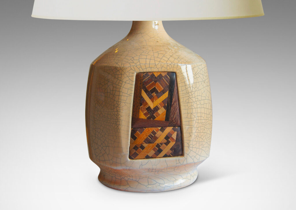 Gallery BAC panel of marquetry in a geometric design inset into one of eight faces of an ivory craquelure-glazed globe form on a flanged foot