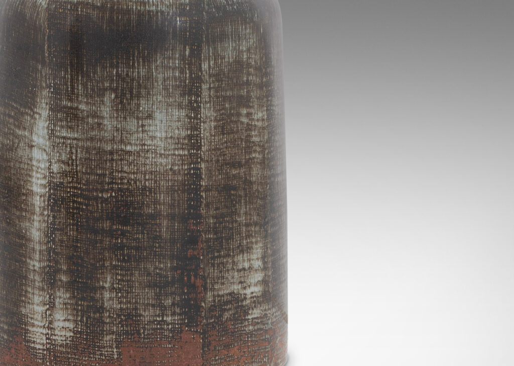 Gallery BAC cylindrical bell form in stoneware with a dry brushed black over green-tinted gray with touches of red luster