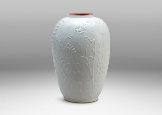 Gallery BAC tall tapering form with relief depictions of wildflowers and an eggshell white finish