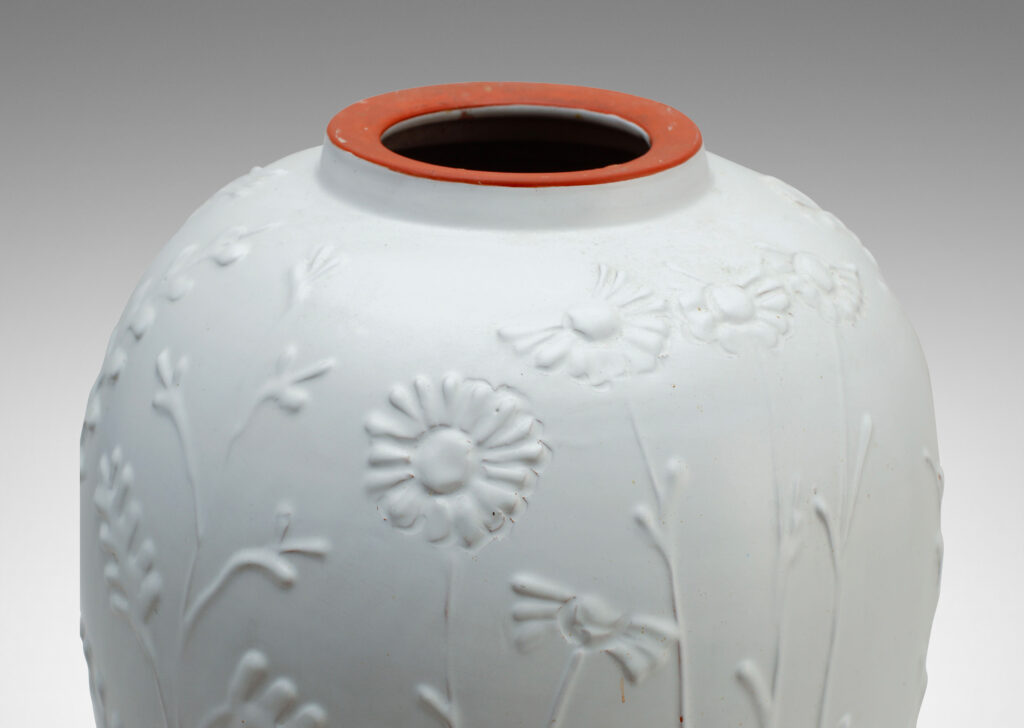 Gallery BAC tall tapering form with relief depictions of wildflowers and an eggshell white finish