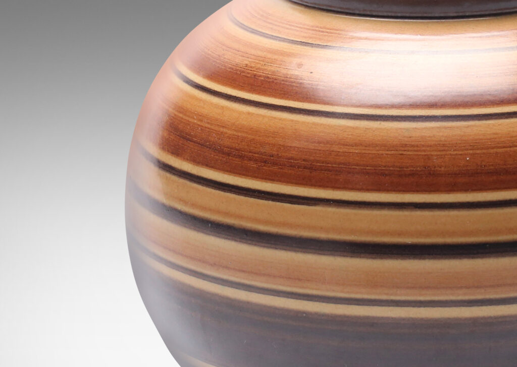 Gallery BAC plump globe form decorated with graded and solid tone stripes in various widths in brown over tan glazing