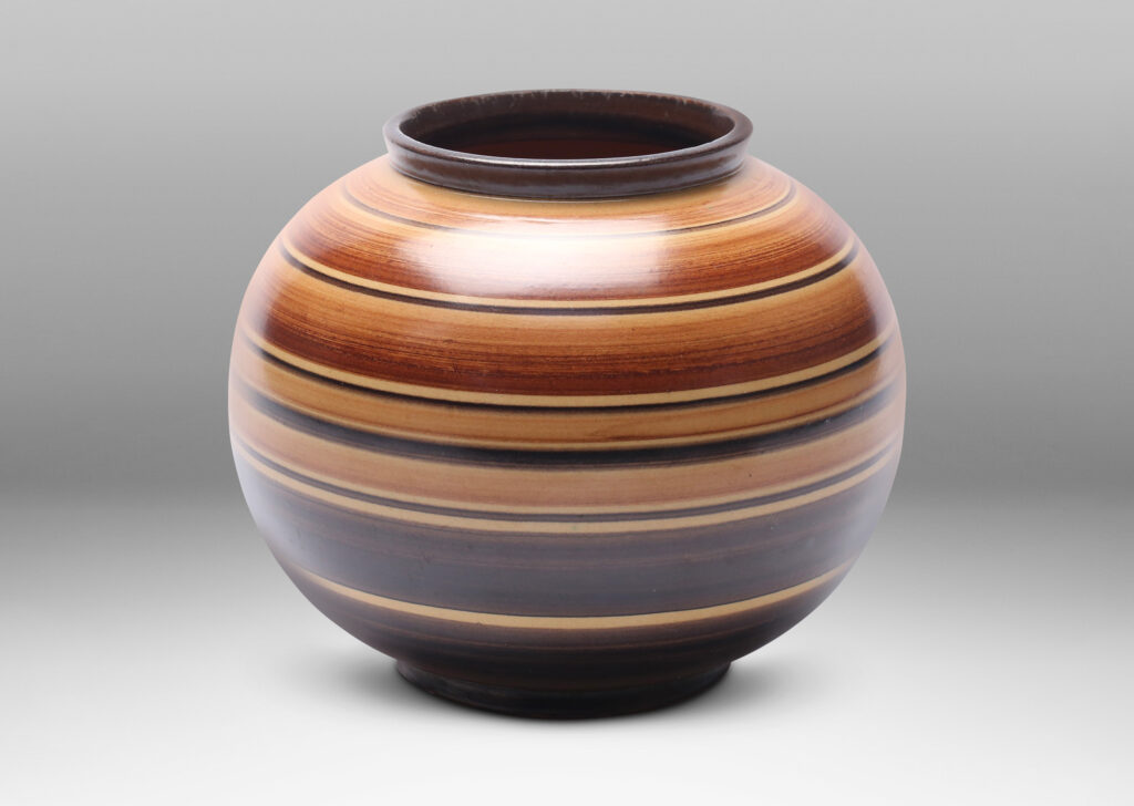 Gallery BAC plump globe form decorated with graded and solid tone stripes in various widths in brown over tan glazing