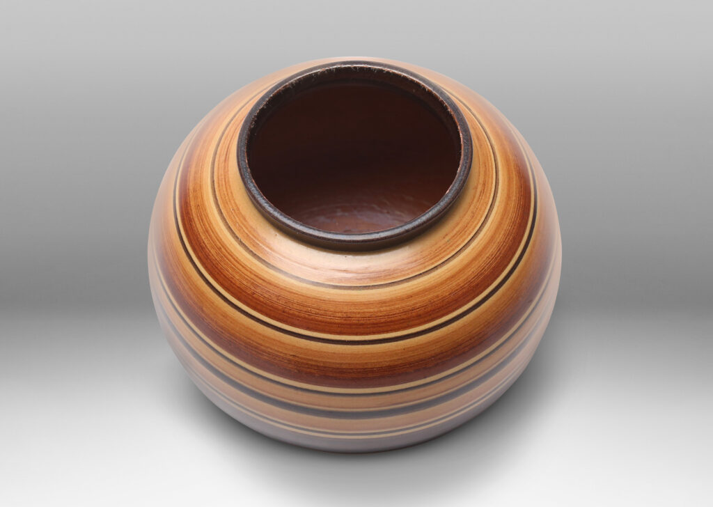 Gallery BAC plump globe form decorated with graded and solid tone stripes in various widths in brown over tan glazing