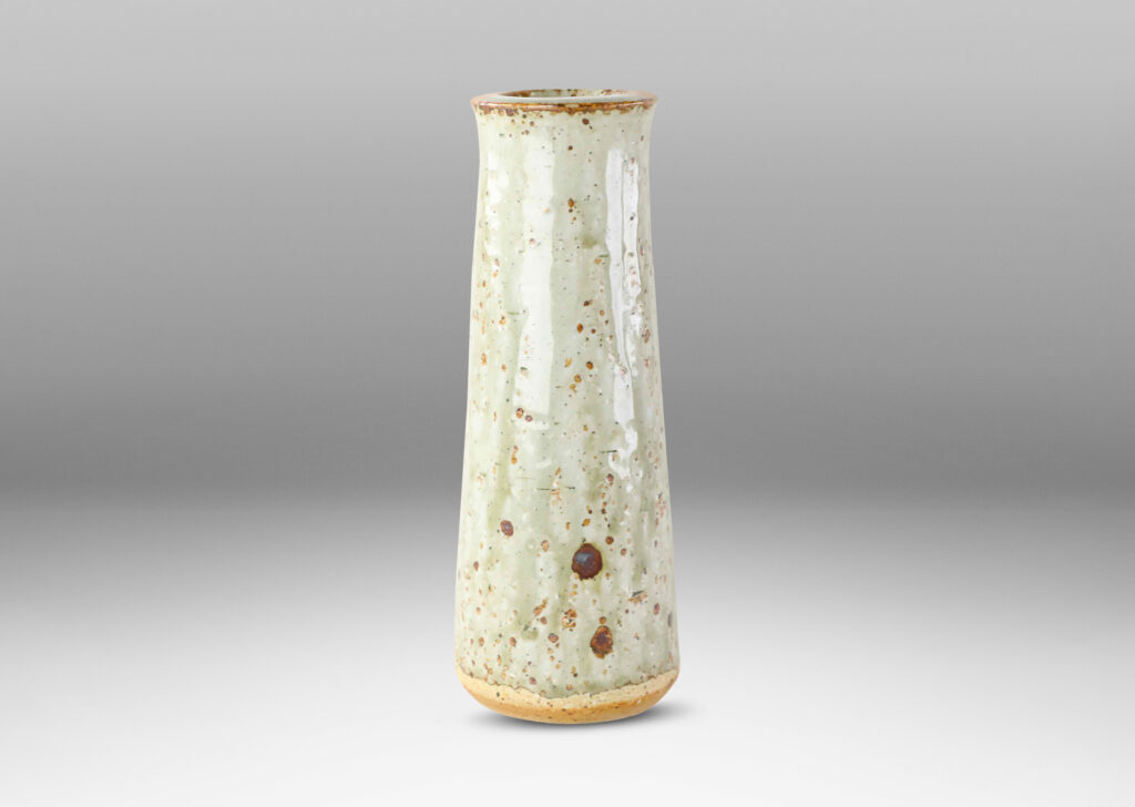 Gallery BAC tall raked cylindrical form with flared lip in a shiny gray-green glaze with brown speckles