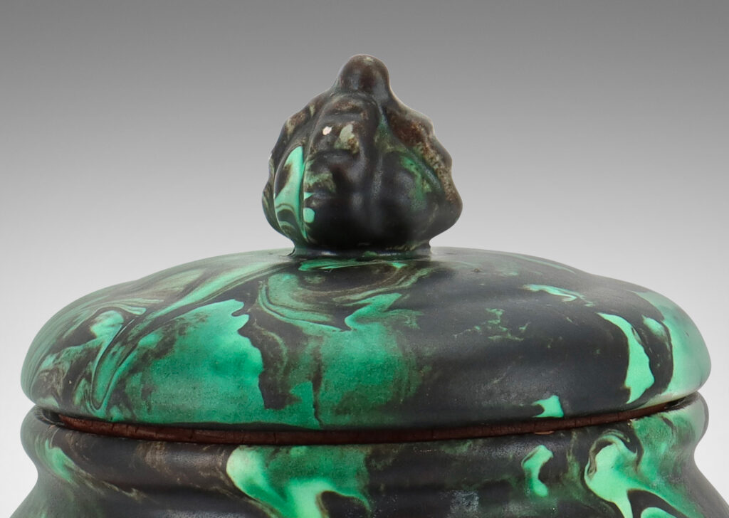 Gallery BAC undulating form with flower-topped finial in marbelized green and black matte glaze