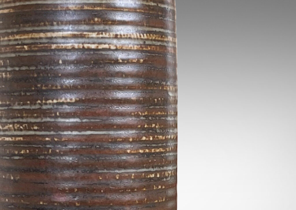 Gallery BAC ridged cylindrical form glazed in a warm brown and pale gray “Sung” glaze with matte brown angled plinth