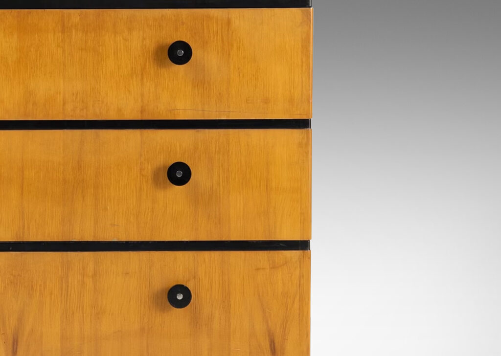Gallery BAC three drawers in blonde birch stacked between thin ebonized bands, with ebonized pulls, top and pier legs