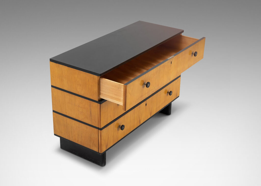 Gallery BAC three drawers in blonde birch stacked between thin ebonized bands, with ebonized pulls, top and pier legs