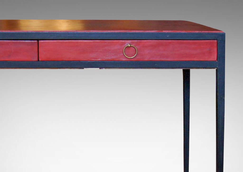 Gallery BAC iron frame ending in attenuated tapering legs, oak casework covered with red-brown leather, and brass ring pulls