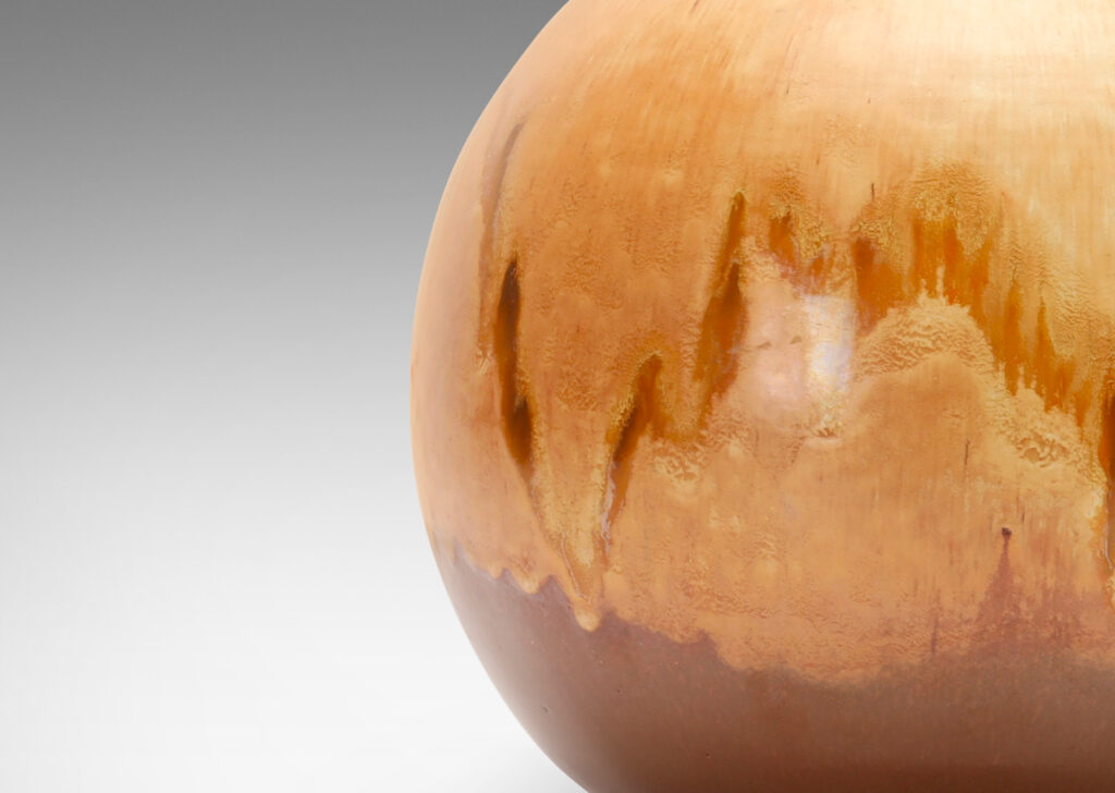 Gallery BAC having a globe form with a flowing brown and sandy tone glazing evocative of birch burl