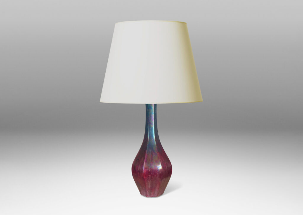 Gallery BAC octagonally-faceted decanter form with attenuated neck, glazed in berry red and teal luster