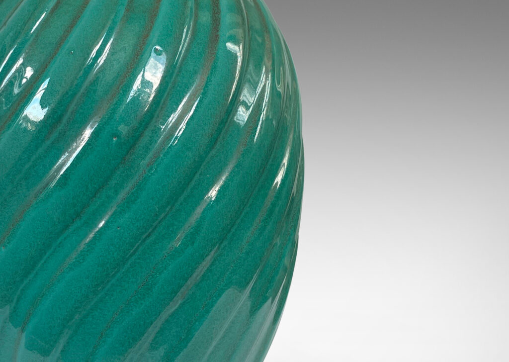 Gallery BAC fluted upright oval forms with vertical fluting; ceramic with a deep teal copper oxide glaze