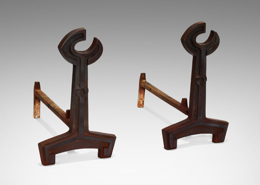 Gallery BAC andirons with crescent finials, springing form and articulating relief design