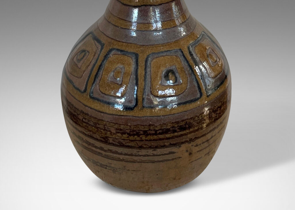 Gallery BAC bulbous form with tall conical neck, glazed in brown luster tones, with pattern of stripes and concentric square motifs