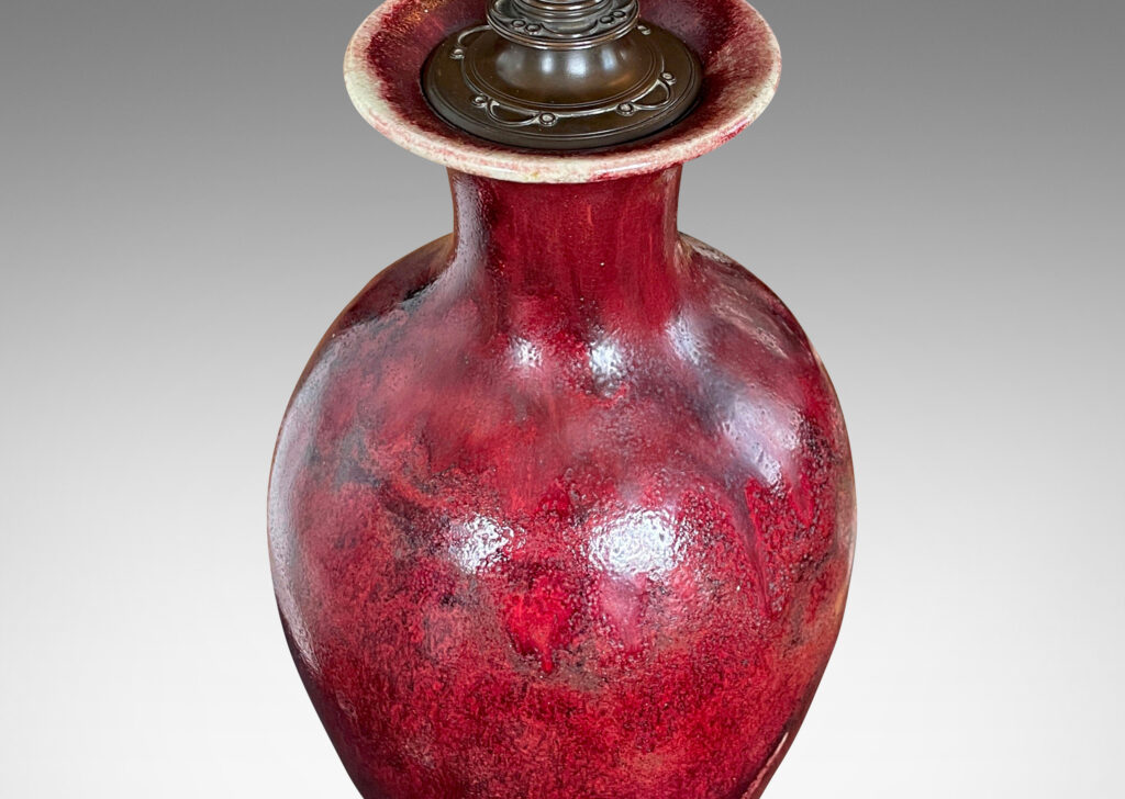 Gallery BAC modeled after a Chinese plum vase form, magnificently finished in deep red flambé glaze with just the right touches of purple and painterly flowing swagging