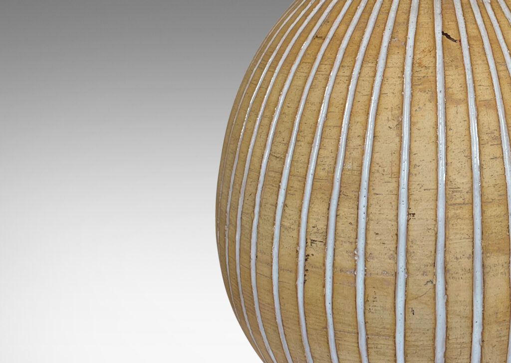 Gallery BAC bulbous form in an unglazed sandy tone, with carved vertical pinstripes glazed gloss white