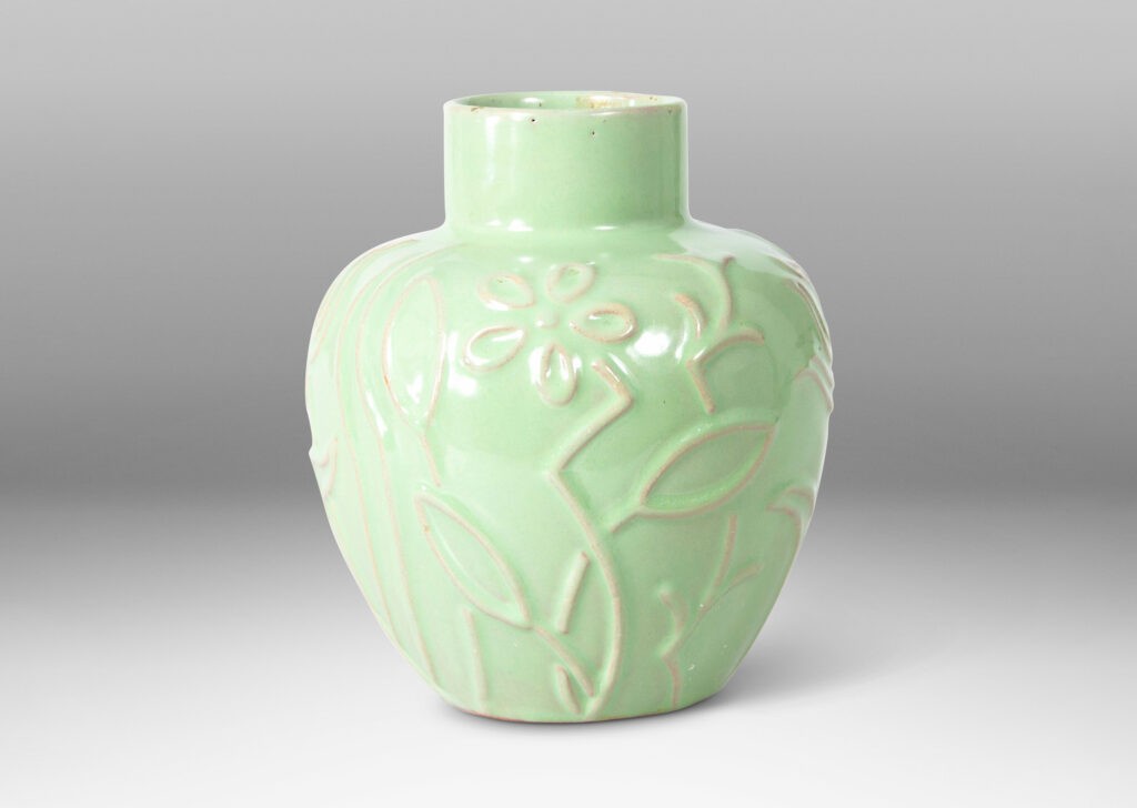 Gallery BAC apple-like shape ornamented with stylized floral reliefs and glazed in a bright celadon tone