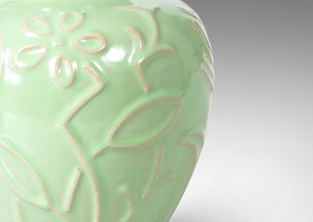 Gallery BAC apple-like shape ornamented with stylized floral reliefs and glazed in a bright celadon tone