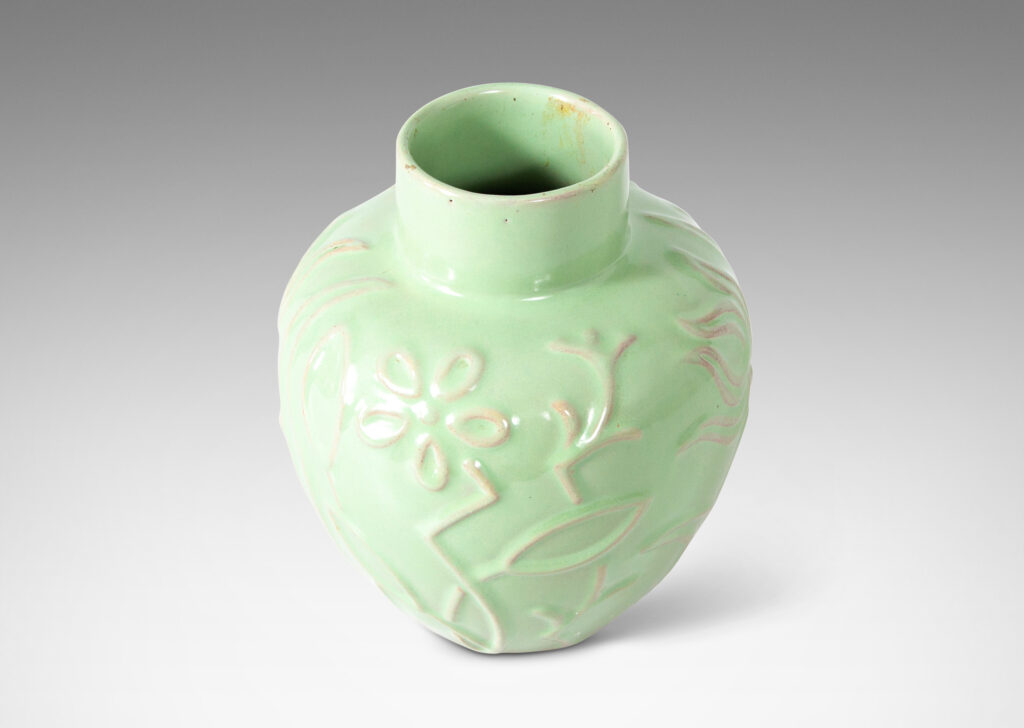 Gallery BAC apple-like shape ornamented with stylized floral reliefs and glazed in a bright celadon tone