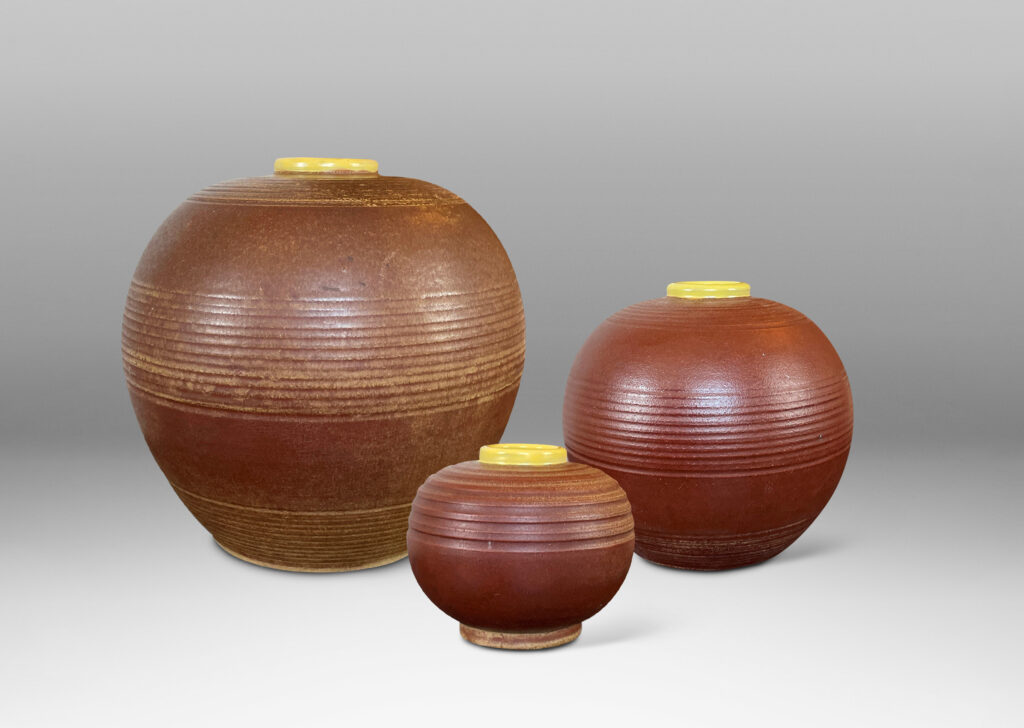 Gallery BAC globe forms with carved pinstripe banding, glazed in brown and yellow