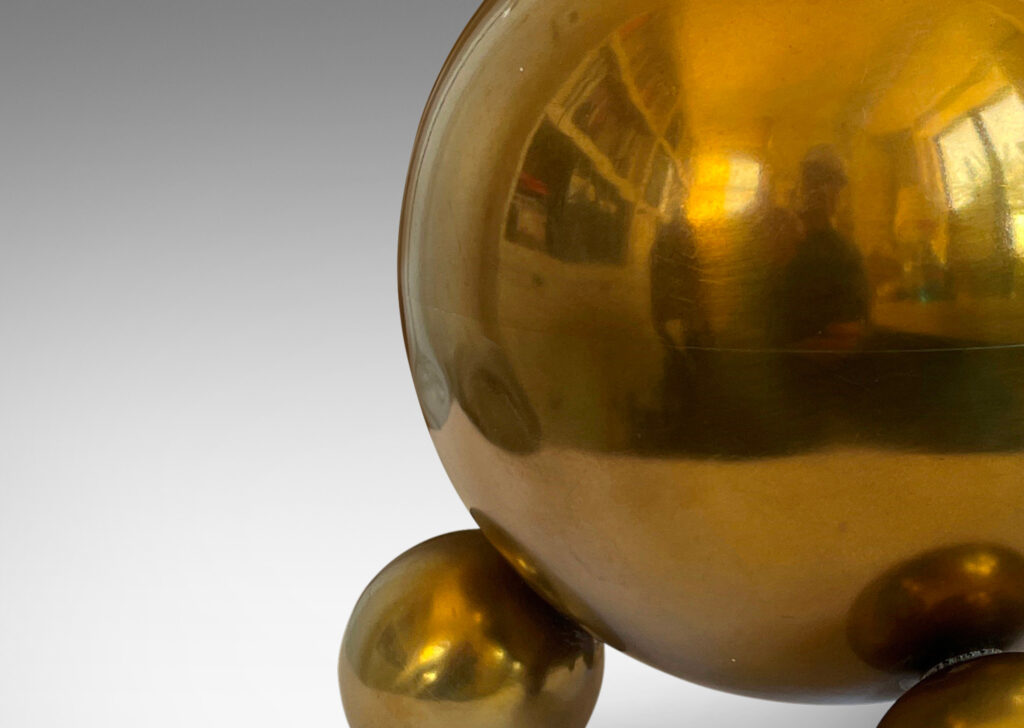 Gallery BAC globe forms perched on trios of smaller spheres; brass