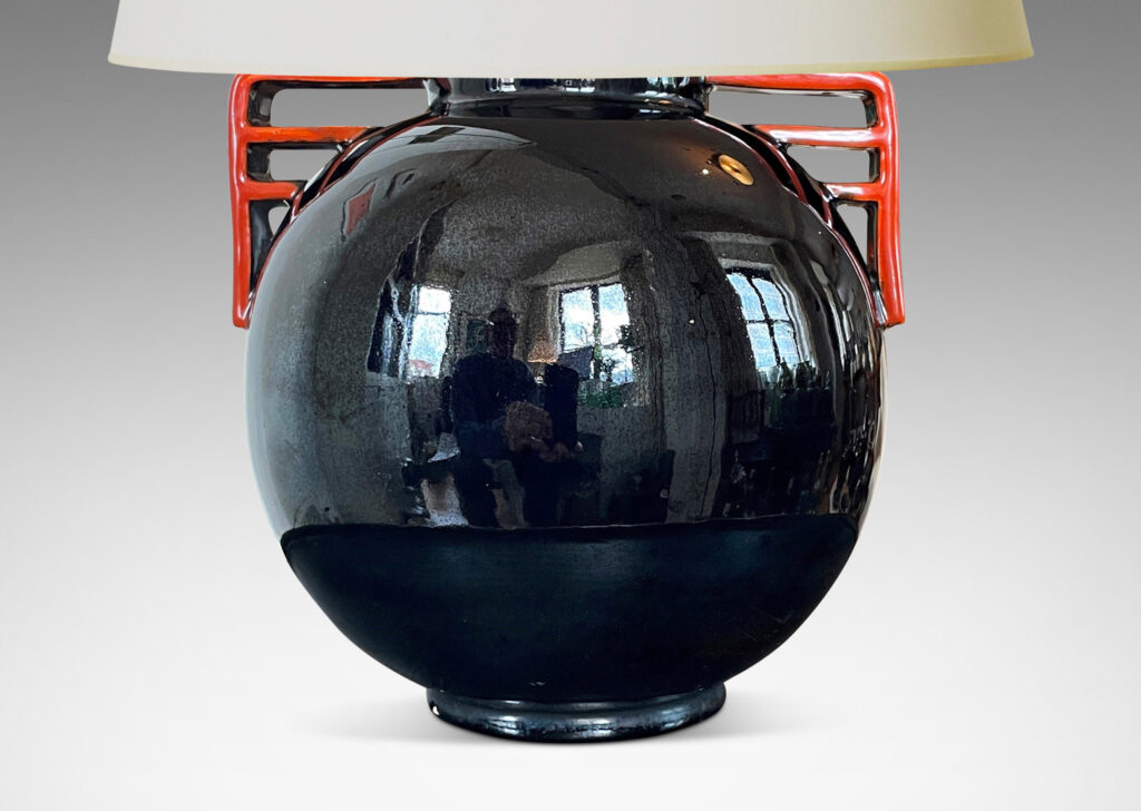 Gallery BAC globe form glazed in a gloss black with vermillion bracket handles