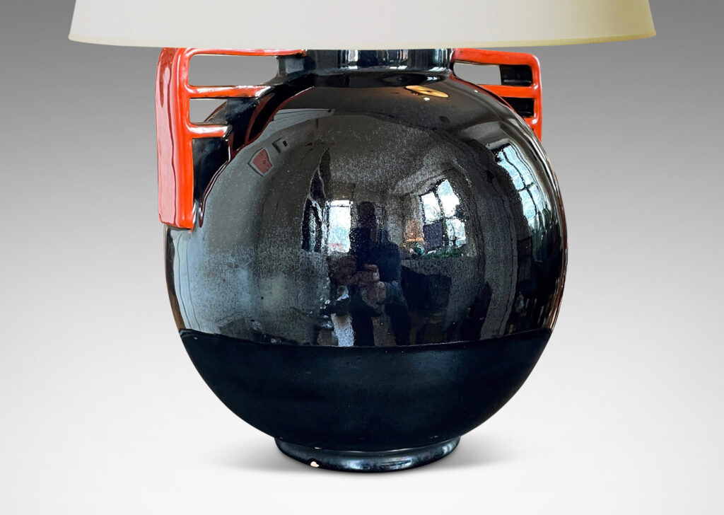 Gallery BAC globe form glazed in a gloss black with vermillion bracket handles