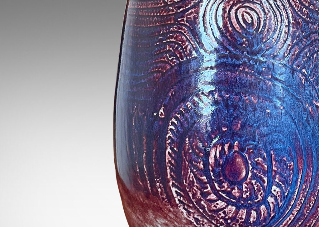 Gallery BAC Gallery BAC ovoid form with wide mouth and carved organic coiling and radiating linear pattern, glazed in oxblood with hints of purple and pale gray