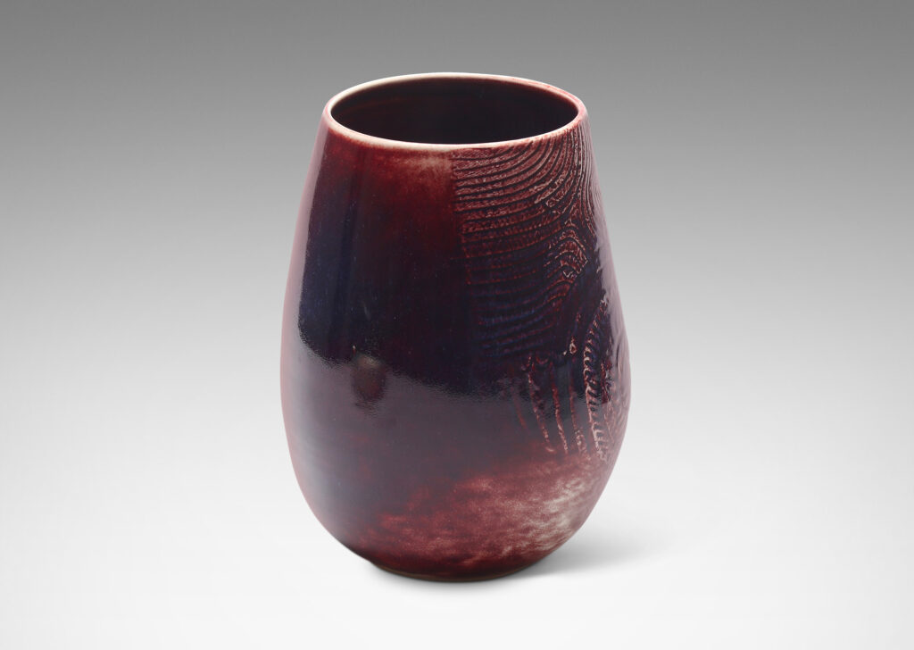 Gallery BAC Gallery BAC ovoid form with wide mouth and carved organic coiling and radiating linear pattern, glazed in oxblood with hints of purple and pale gray