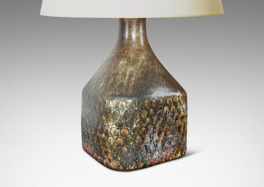 Gallery BAC square bottle-like form with rows of carved circle motifs and sprouting neck, glazed in a greenish-gray tone