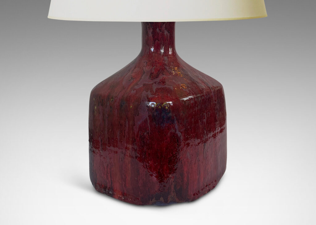 Gallery BAC square bottle-like form with rows of carved circle motifs and sprouting neck, glazed in a thick flowing burgundy-oxblood tone