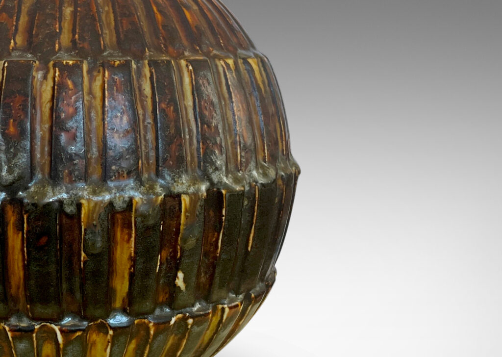 Gallery BAC globe form with rows of rectangular blocks in relief, glazed in a rare dark brown tone