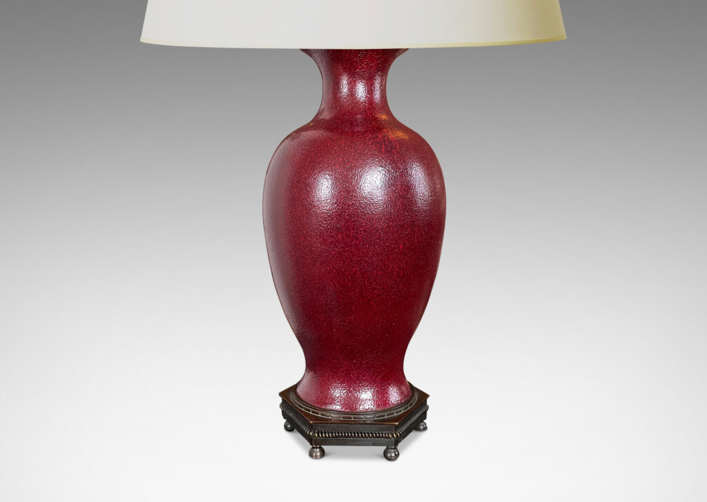 Gallery BAC elegant vase form glazed in a rich oxblood glaze with a subtle orange peel finish, mounted on an octagonal base