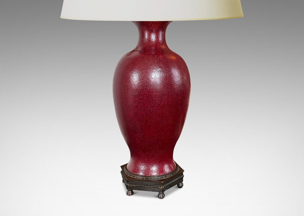 Gallery BAC elegant vase form glazed in a rich oxblood glaze with a subtle orange peel finish, mounted on an octagonal base