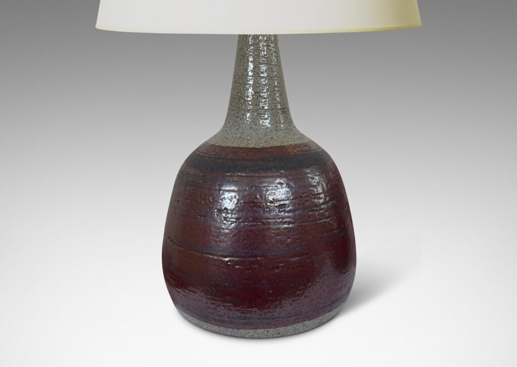 Gallery BAC bulbous forms with tall, conical necks, glazed in pale gray with burgundy luster