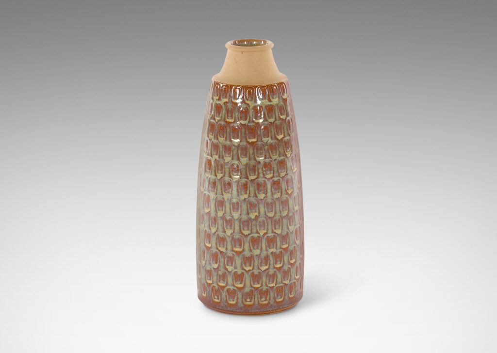 Gallery BAC swelling cylindrical form with impressed oblong motifs and cove neck, glazed in a flowing glossy iridescent beige-tinted clear glaze