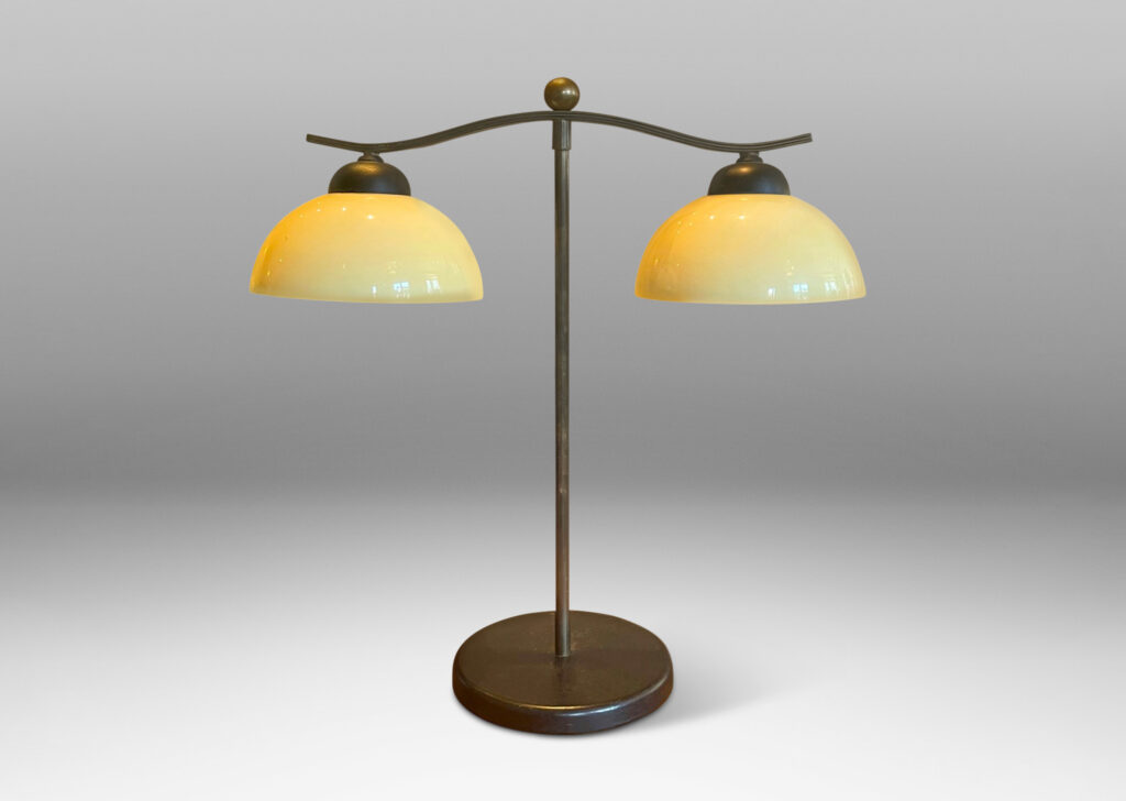 Gallery BAC two lights with demi-lune ivory opaline glass shades, mounted on an undulating arm with straight stand and ball finial in brass