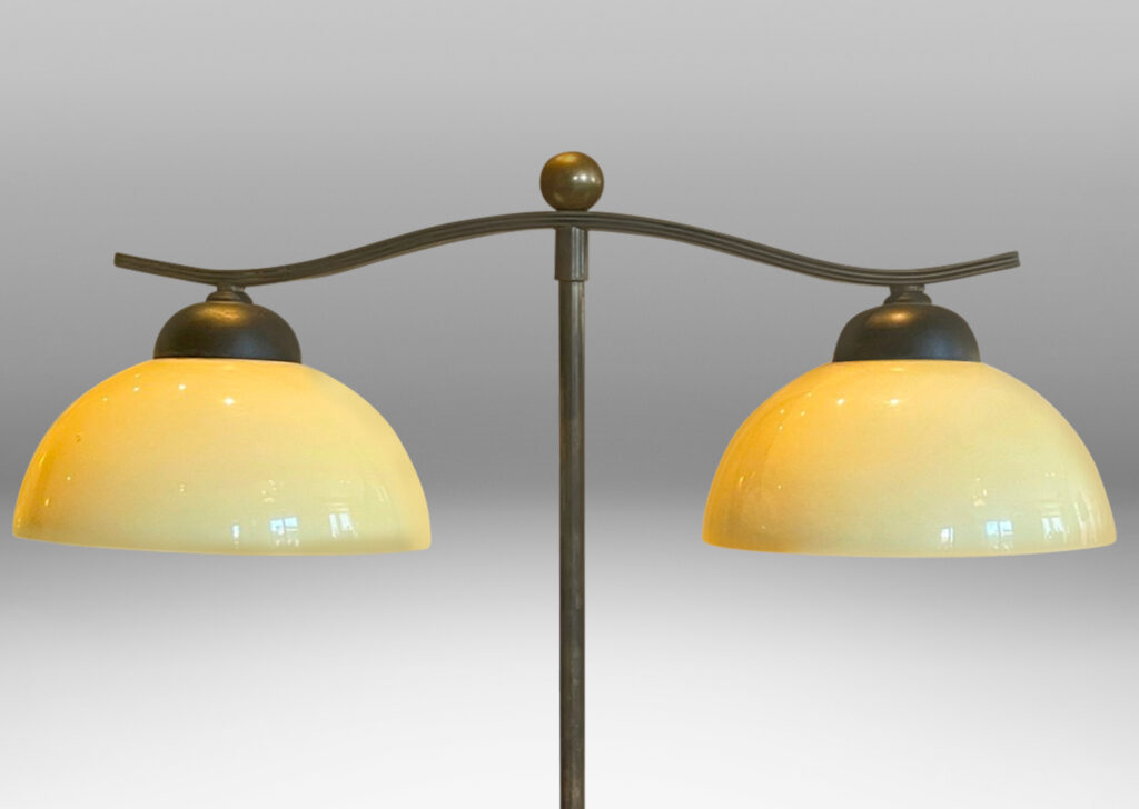 Gallery BAC two lights with demi-lune ivory opaline glass shades, mounted on an undulating arm with straight stand and ball finial in brass