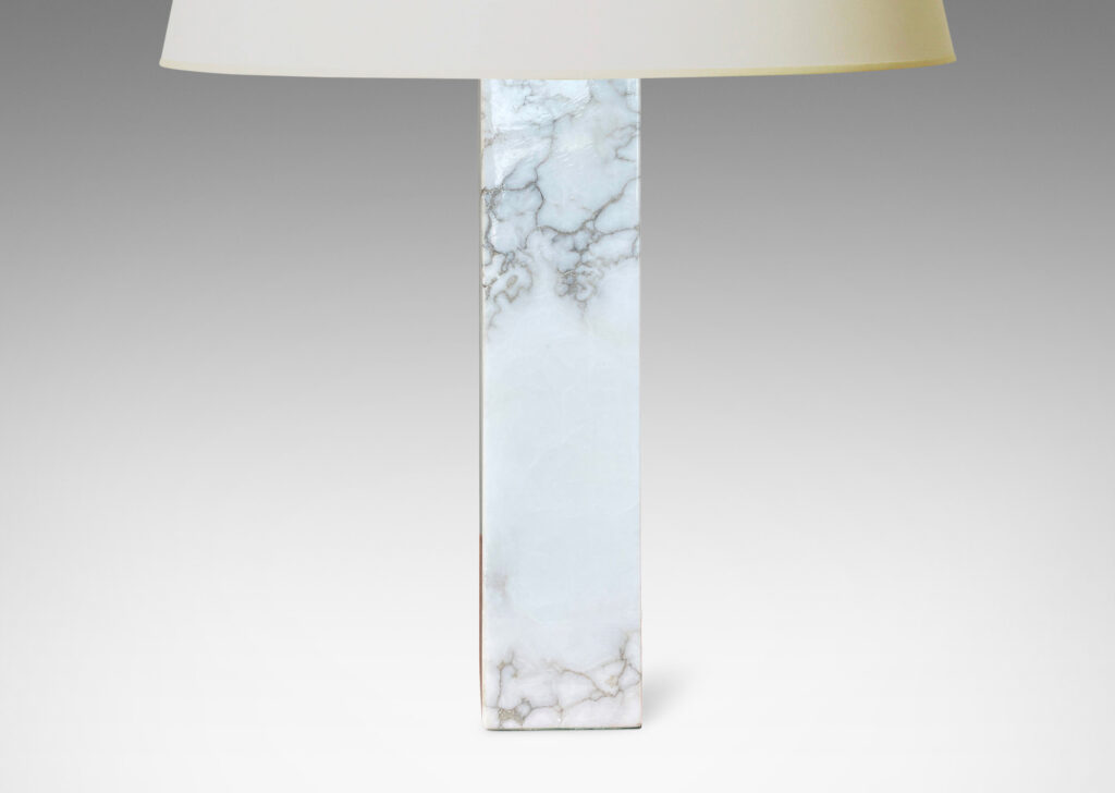 Gallery BAC having square pillar forms cut from solid marble in white with gray graining;