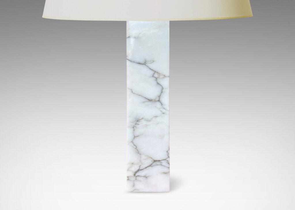 Gallery BAC having square pillar forms cut from solid marble in white with gray graining;