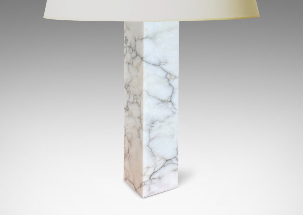 Gallery BAC having square pillar forms cut from solid marble in white with gray graining;