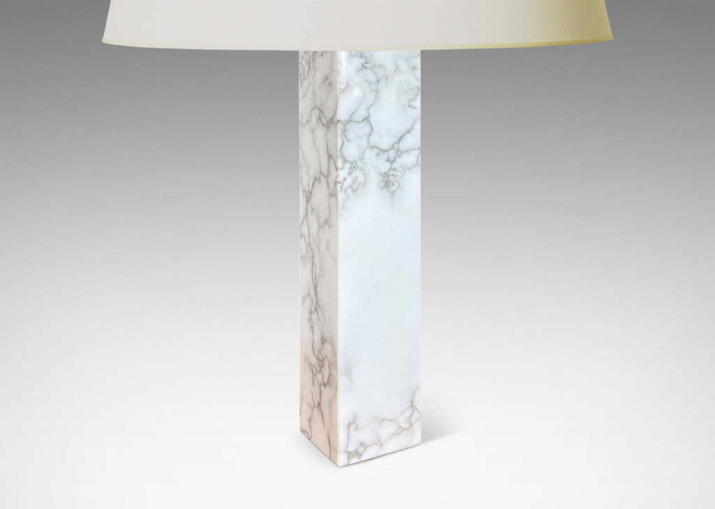 Gallery BAC having square pillar forms cut from solid marble in white with gray graining;