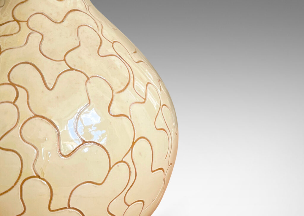 Gallery BAC decanter form with tall neck, glazed in a gloss ivory-cream and decorated with a sgraffito leaf pattern